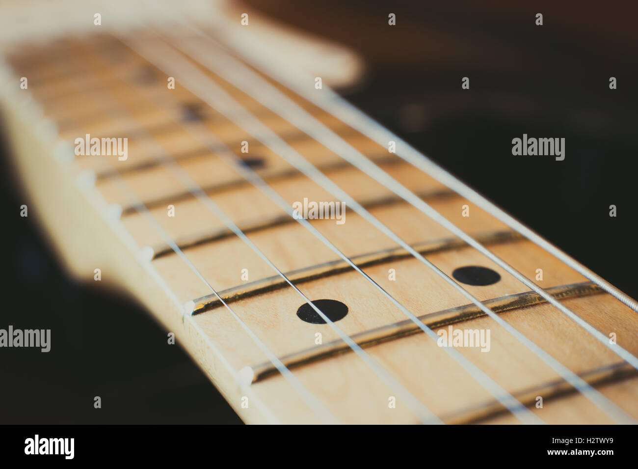 Manche de guitare électrique détail avec effet de lumière, couple de marqueurs point selective focus Banque D'Images