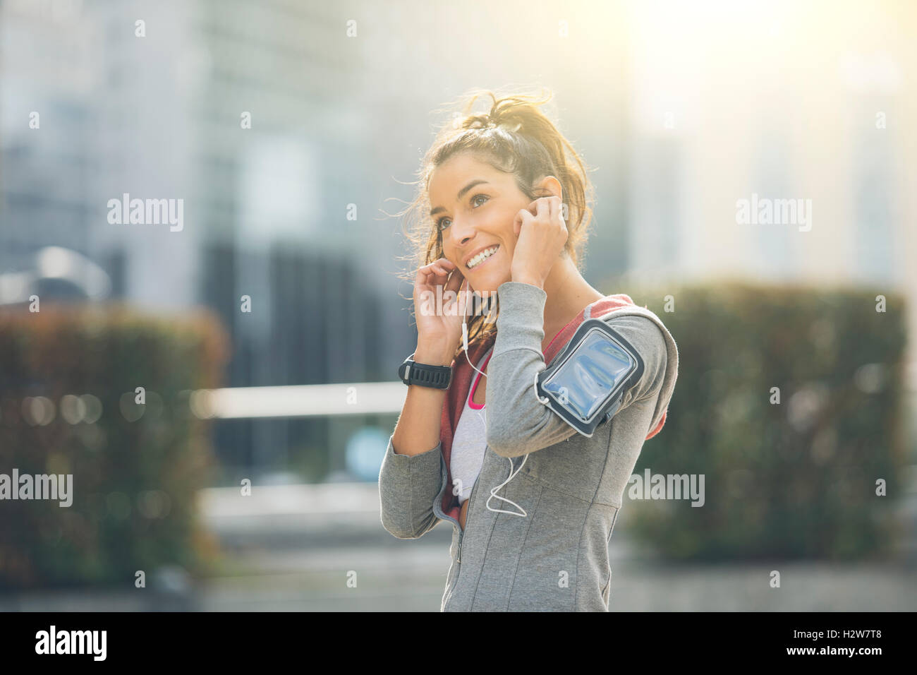 Belle jeune femme athlète coureur insérer ses écouteurs au cours de la formation Banque D'Images