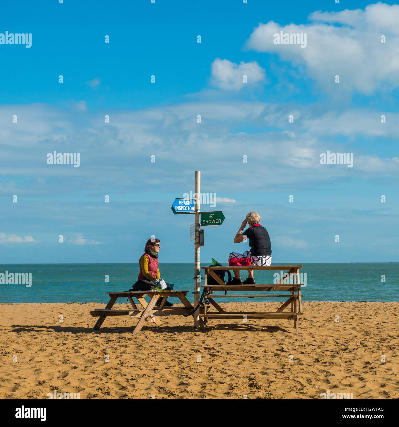 Deux femmes savoir profiter de l'hiver soleil sur Broadstairs Beach Banque D'Images