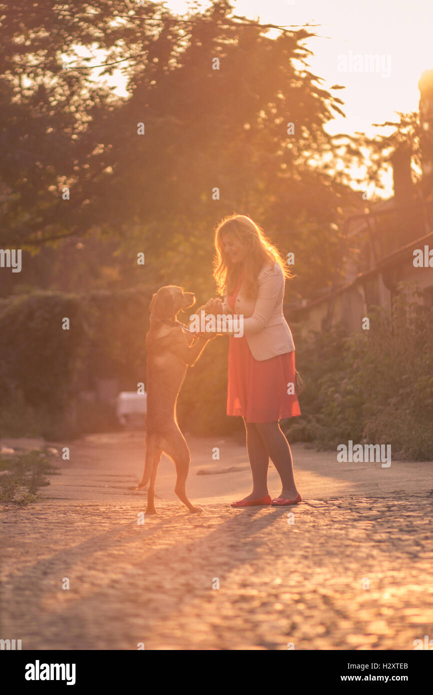 Happy smiling young woman chien mains couleurs orange Banque D'Images