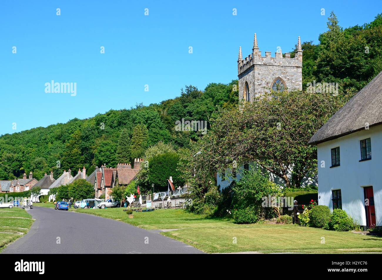 Afficher le long de la rue de ce joli village avec l'église au premier plan, Milton Abbas, Dorset, Angleterre, Royaume-Uni, Europe de l'Ouest. Banque D'Images