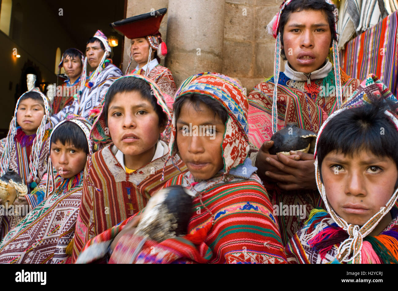 La montagne des gens habillés en costumes traditionnels à la porte de l'église de Pisac Dimanche Jour de marché. Pisac. Vallée Sacrée. Banque D'Images