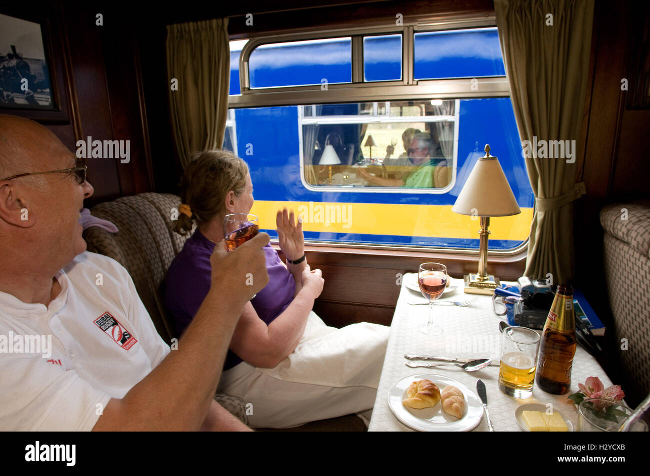 Communauté andine Explorer, bateau train de Cusco à Puno. Former à l'intérieur. Certains passagers accueillir les passagers dans le passage direct en face Banque D'Images