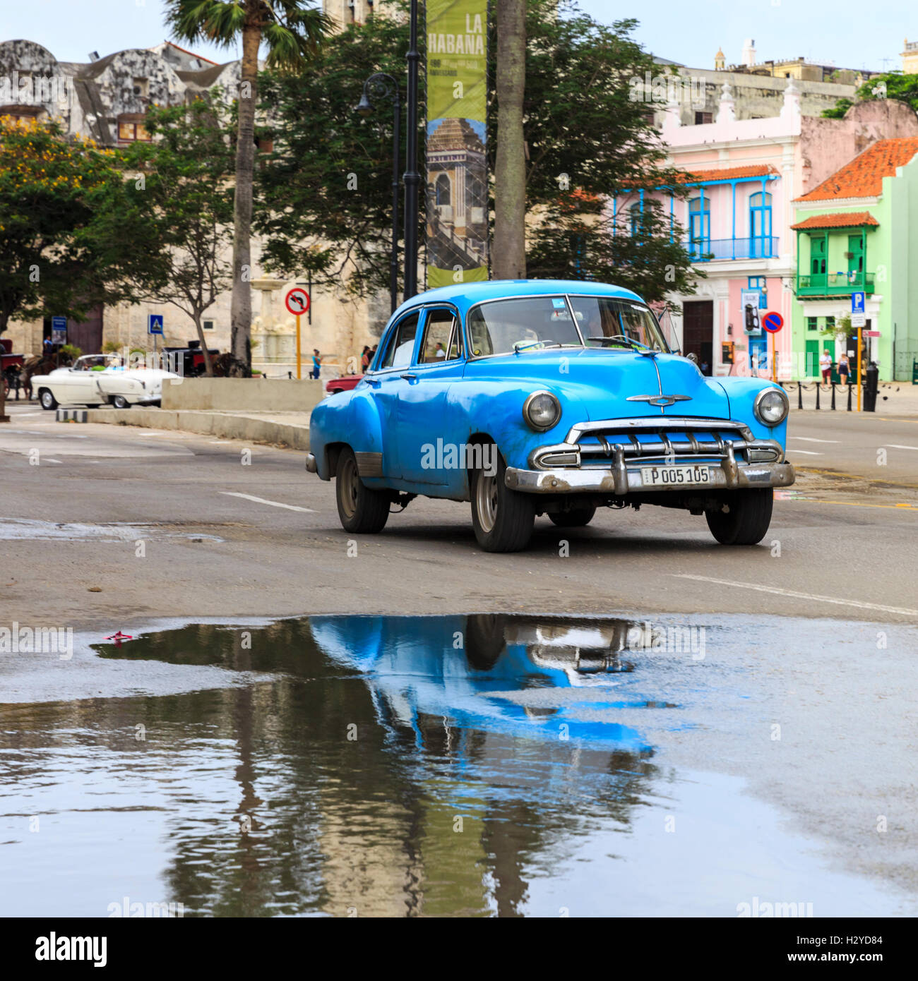 Scène de rue à La Havane : bleu voiture classique et de réflexion dans la Vieille Havane, Cuba Banque D'Images