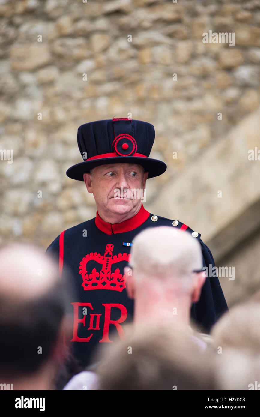 Yeoman Warder Guardsman regarder touriste sur une visite guidée de la Tour de Londres, London,UK Banque D'Images