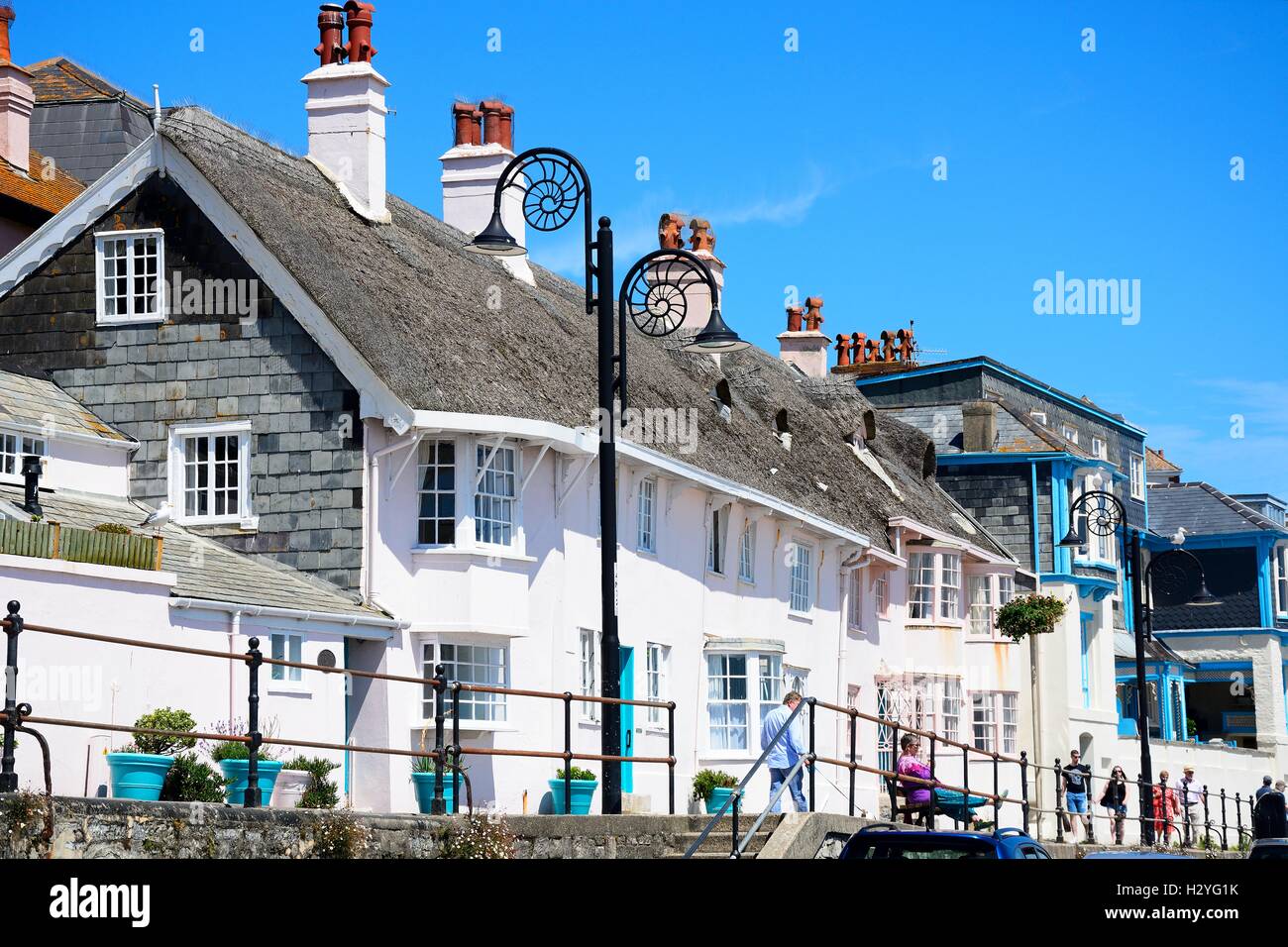 Bâtiments le long de la promenade avec l'ammonite décorées de réverbères, Lyme Regis, dans le Dorset, Angleterre, Royaume-Uni, Europe de l'Ouest. Banque D'Images