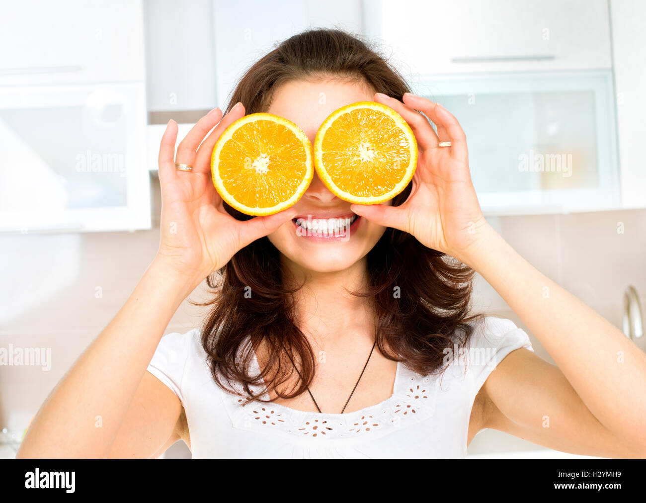 Femme drôle avec Orange au-dessus des yeux dans la cuisine Banque D'Images