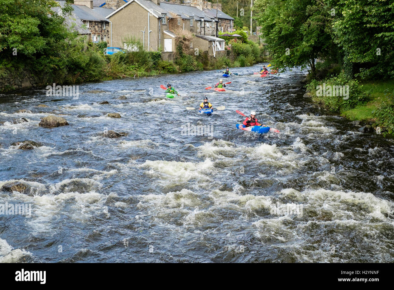 Un groupe de kayakistes en kayak kayaks Pyranha bas courant rapide de la rivière Glaslyn Afon de Snowdonia. Gwynedd au Pays de Galles UK Beddgelert Banque D'Images