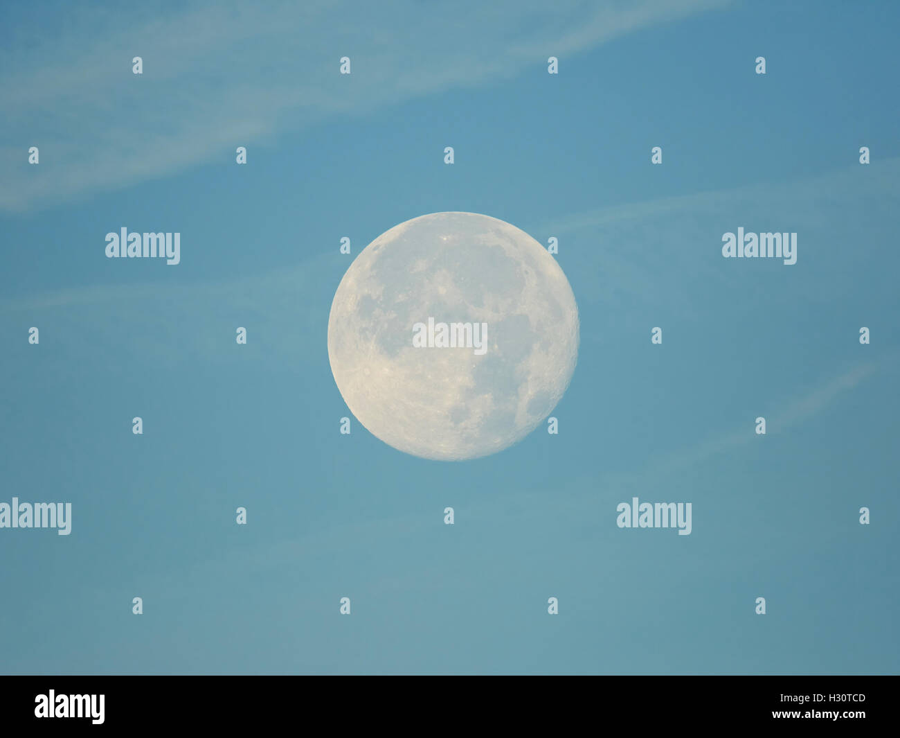 Pleine lune dans journée sur un ciel bleu et des nuages Banque D'Images