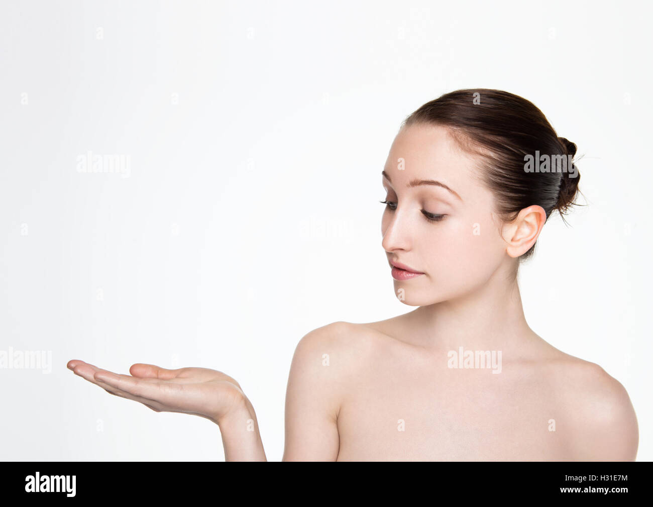 Les femmes de beauté maquillage naturel holding jusqu'à bras pour le texte sur fond blanc Banque D'Images