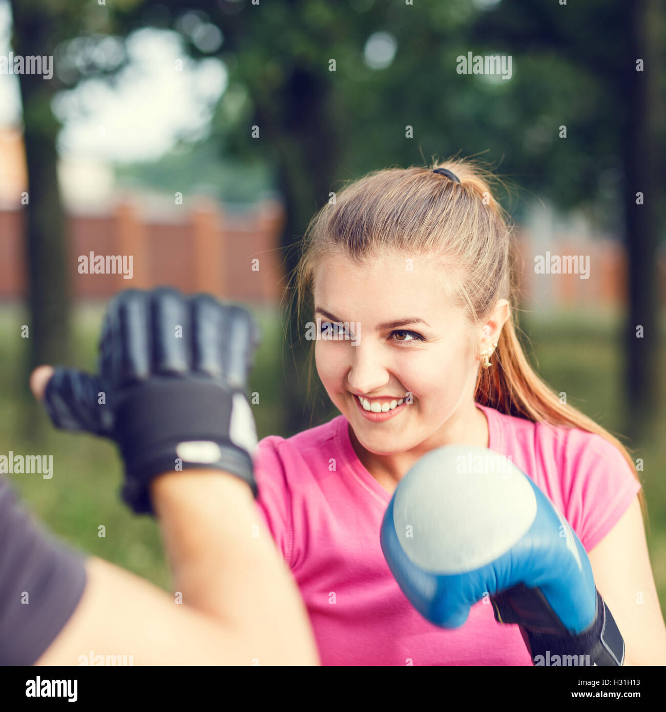 Jeune femme sportive de boxe d'entraînement avec un instructeur au parc. Entraînement à l'extérieur de remise en forme Banque D'Images