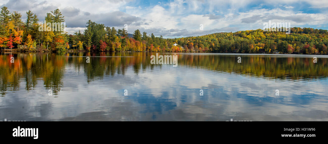 Réflexions du ciel et de l'automne feuillage sur Bryant Pond dans le Maine. Banque D'Images