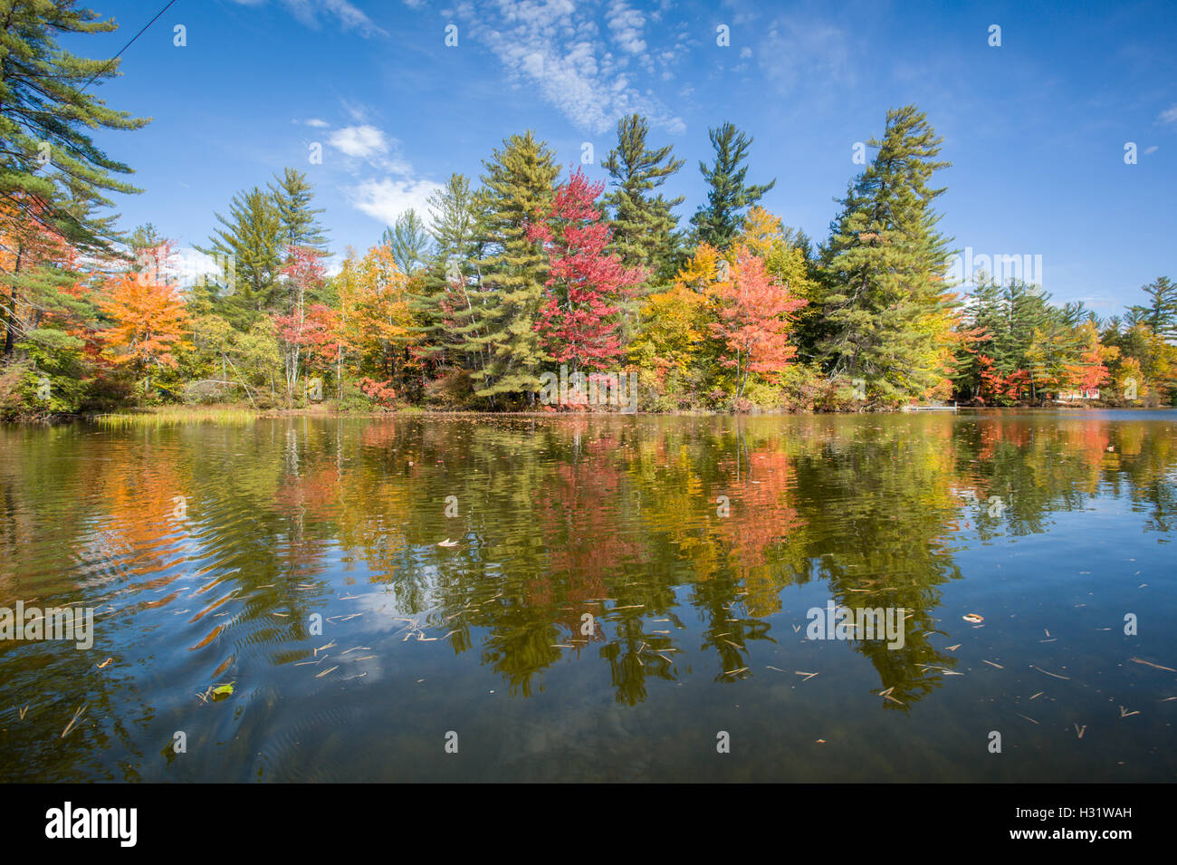 Réflexions du ciel et de l'automne feuillage sur Bryant Pond dans le Maine. Banque D'Images