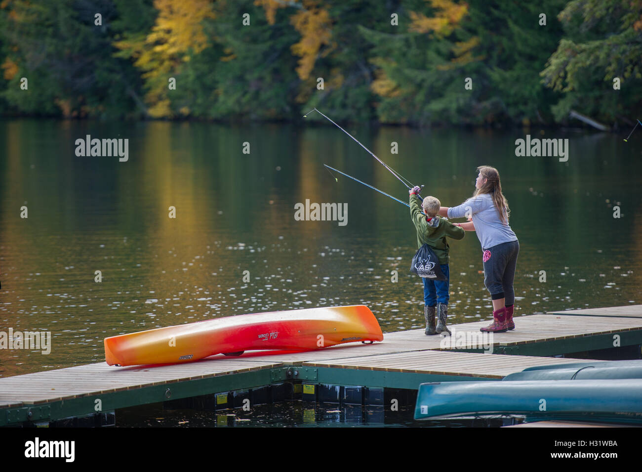 Sur le quai de pêche de l'enfant au Bryant Pond dans le Maine. Banque D'Images