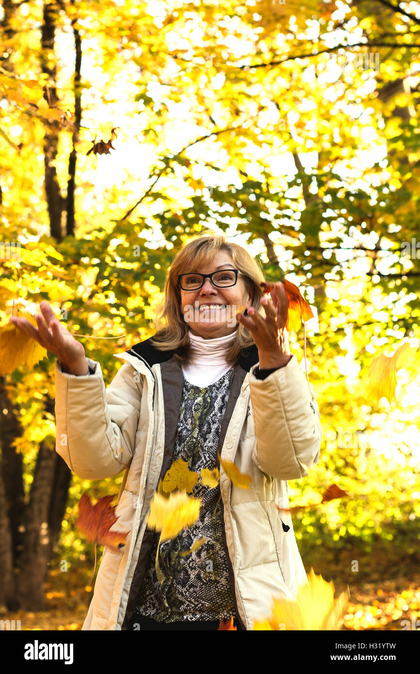 Portrait of mature jolie femme jouant avec l'automne Banque D'Images