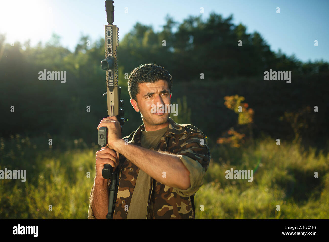 Homme de nationalité arabe de camouflage avec un fusil dans une piscine Banque D'Images