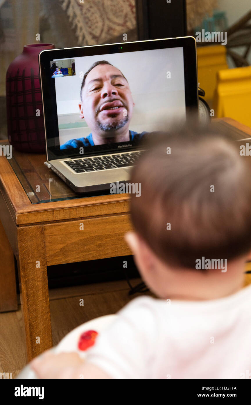 Bébé regardant grand-père sur Skype sur ordinateur Banque D'Images
