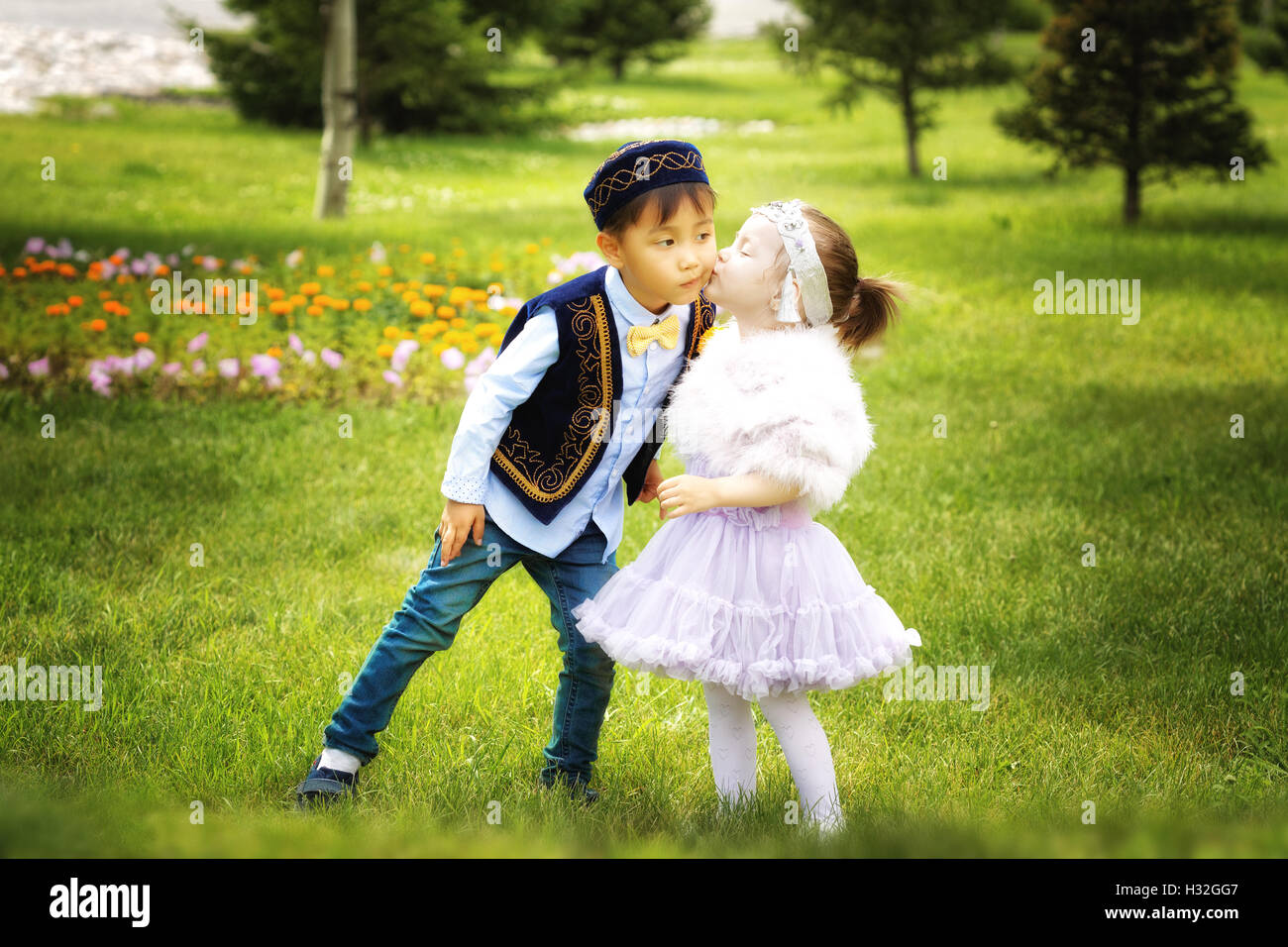 Peu kazakh garçon et fille ensemble jouant dans le parc d'été Banque D'Images