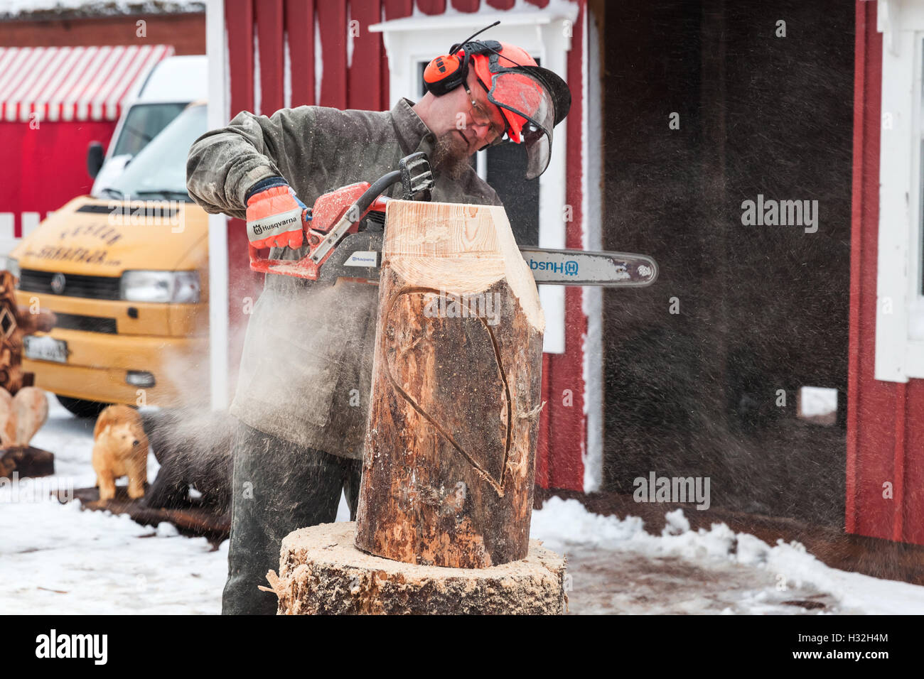 Hamina, Finlande - le 13 décembre 2014 : maître sculpteur avec une tronçonneuse produit oiseau sculpture en bois Banque D'Images