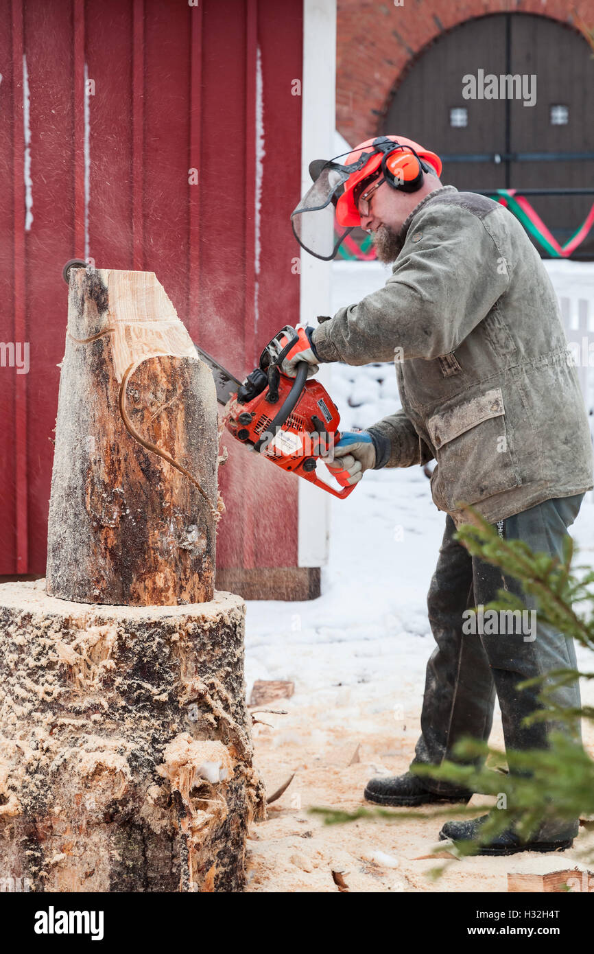 Hamina, Finlande - le 13 décembre 2014 : maître sculpteur finlandais avec une tronçonneuse produit sculpture en bois Banque D'Images
