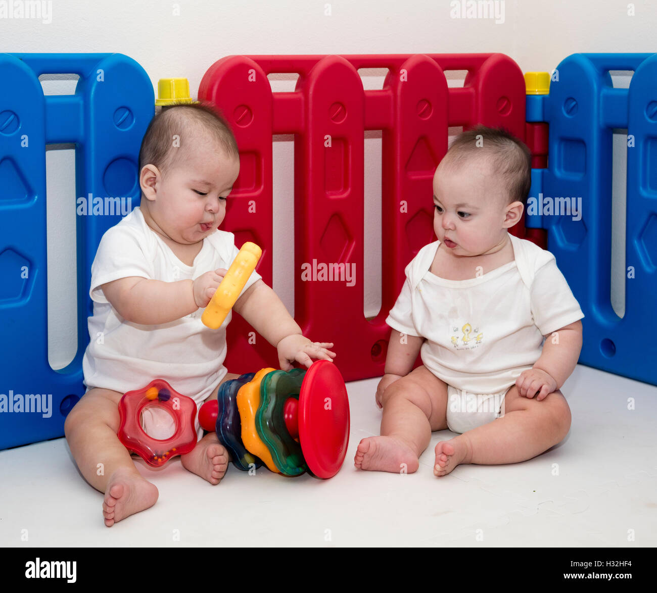 Deux bébés jouant avec l'anneau d'empilage toy Banque D'Images