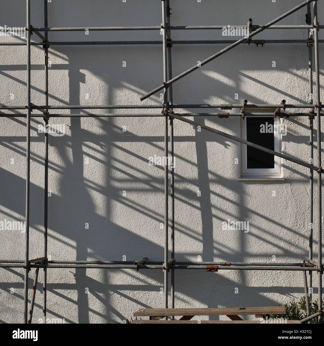 Les ombres de l'échafaudage en diagonale sur pignon de maison mitoyenne Banque D'Images