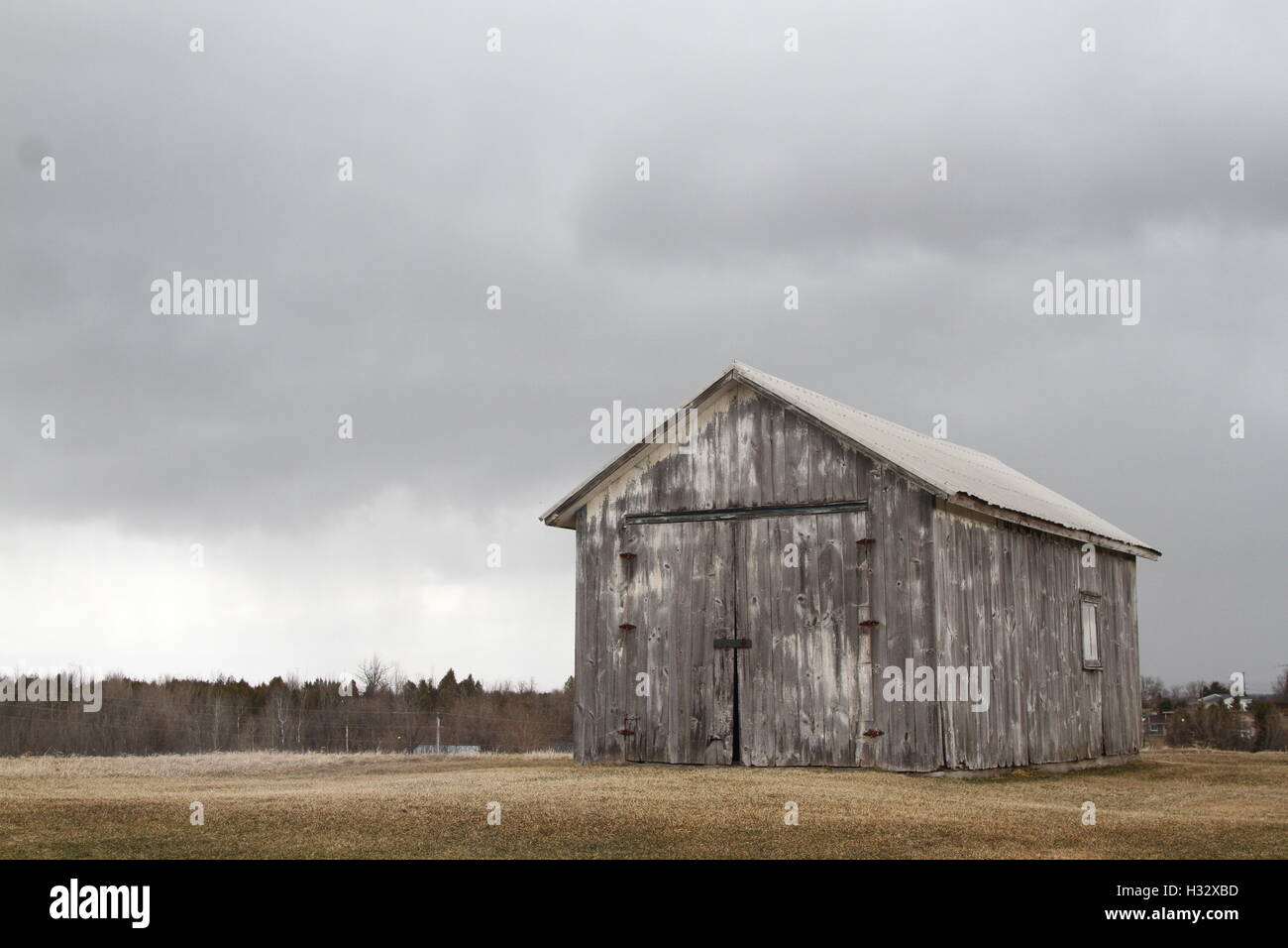 Grange rustique avec de sombres nuages en arrière-plan Banque D'Images