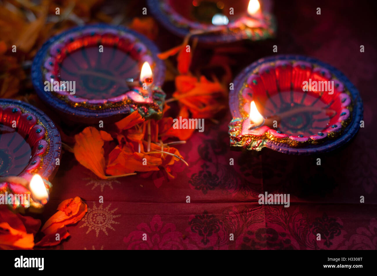 Lampes diya allumé pendant la fête du Diwali avec fleurs et bonbons en arrière-plan Banque D'Images
