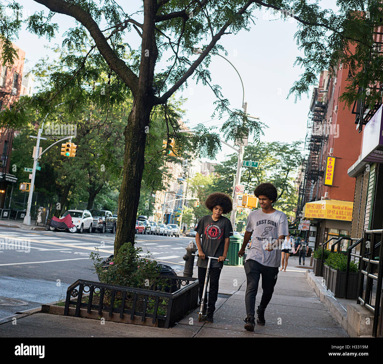 Deux jeunes hommes marchant sur l'Avenue C dans l'East Village. Banque D'Images