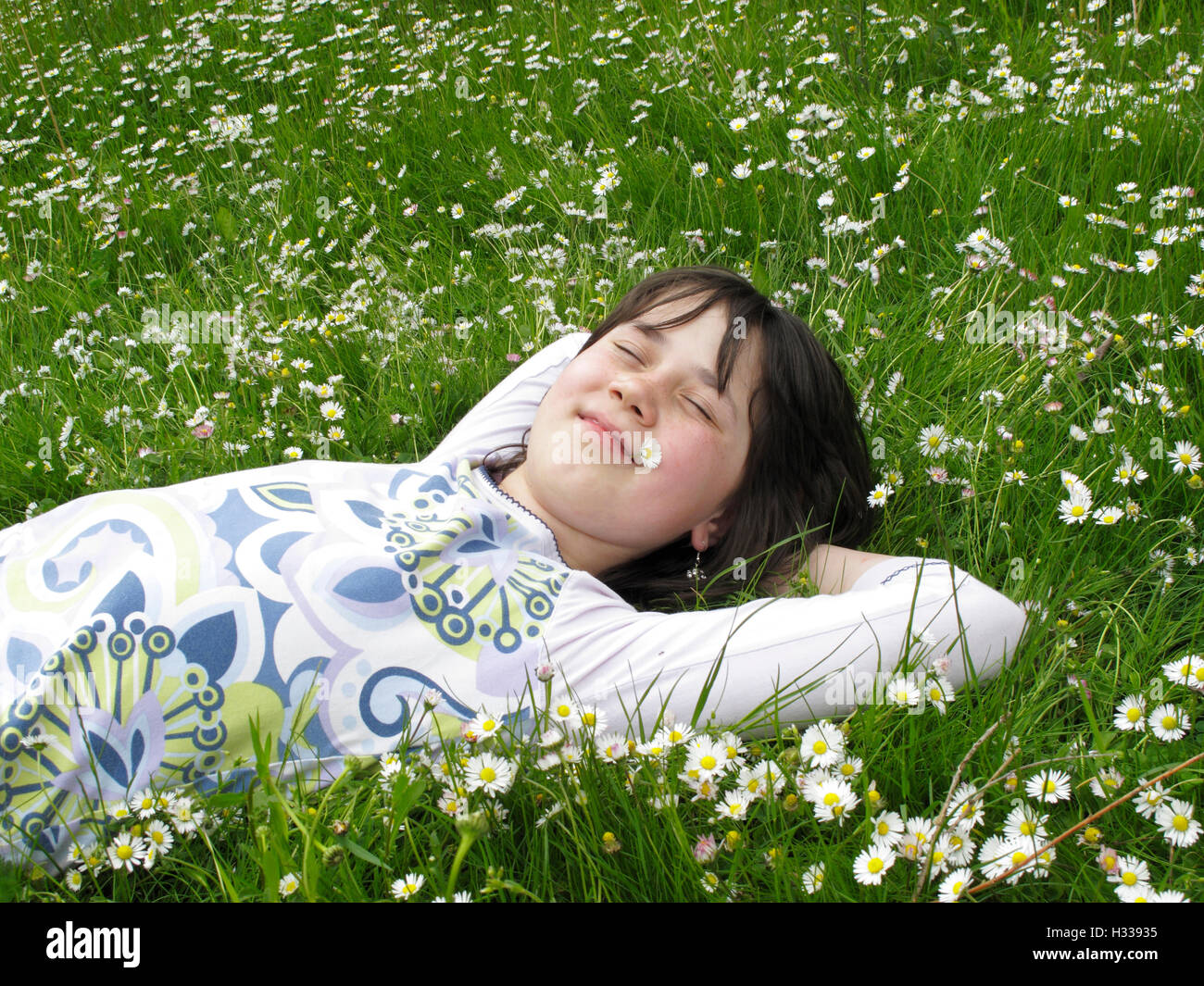 Fille, 8 ans, allongé sur meadow Banque D'Images