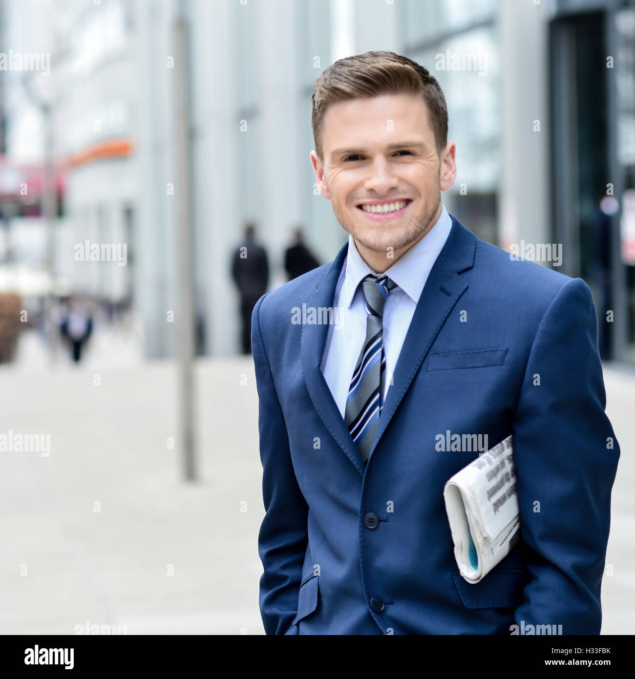 Successful businessman holding newspaper Banque D'Images