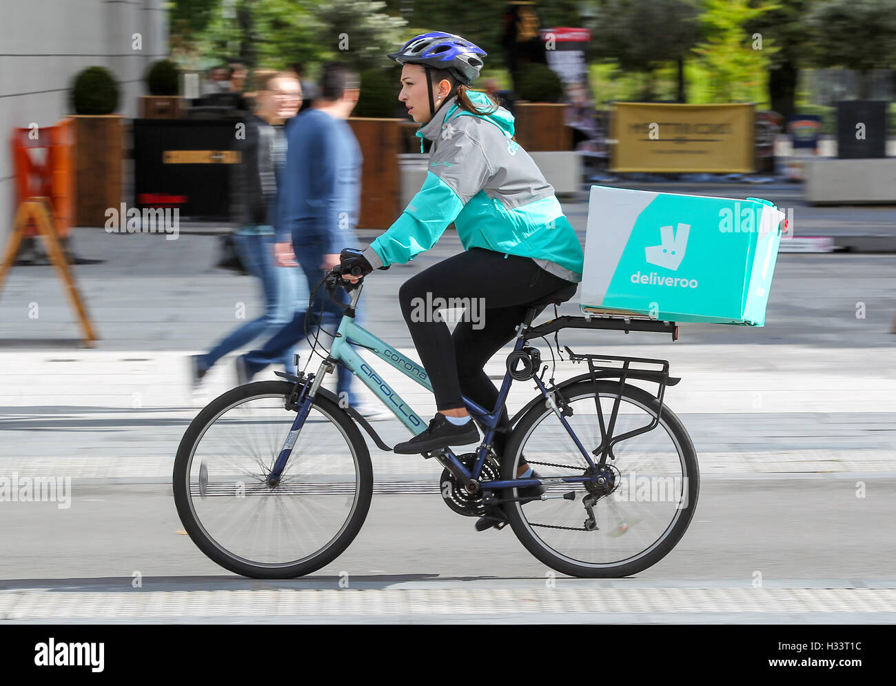 Une femme Deliveroo cyclist riding avec un paquet sur son vélo Banque D'Images