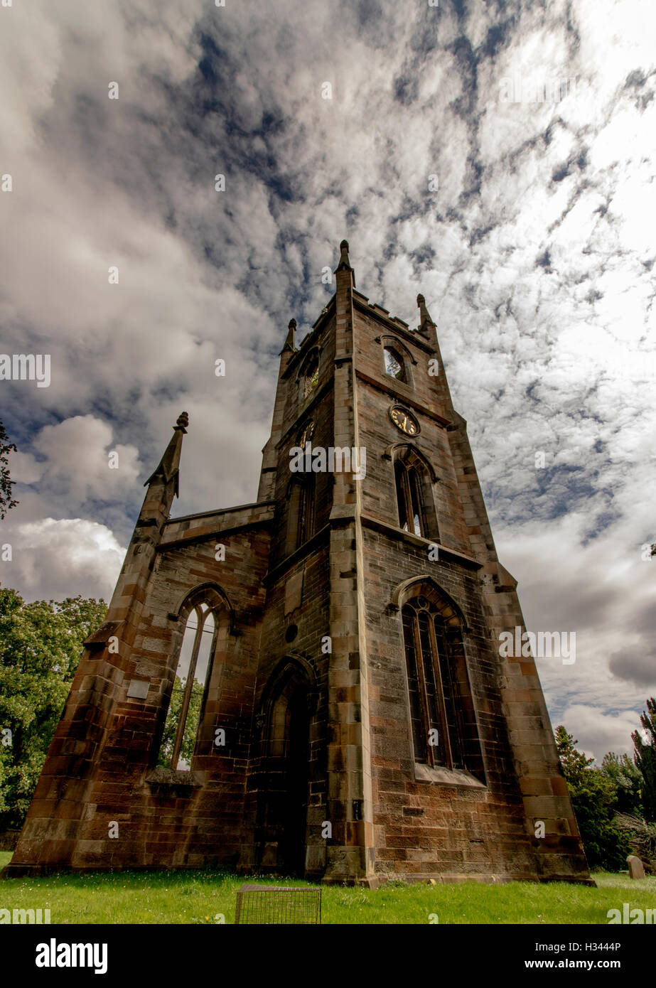 Tour de l'église abandonnée dans un cimetière, low angle avec de jolis nuages dans le ciel Banque D'Images