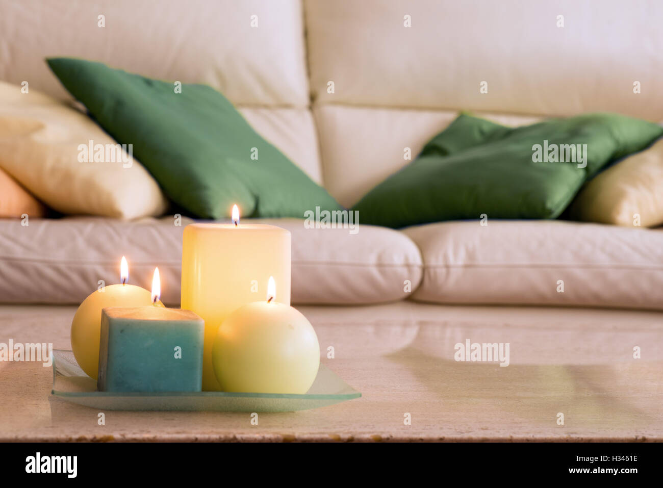 Bougies allumées sur une table en marbre et dans le fond d'un canapé avec des oreillers, qui Banque D'Images