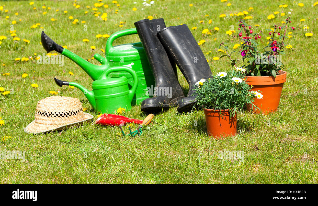 Outils de jardinage et d'un chapeau de paille sur l'herbe dans le jardin Banque D'Images