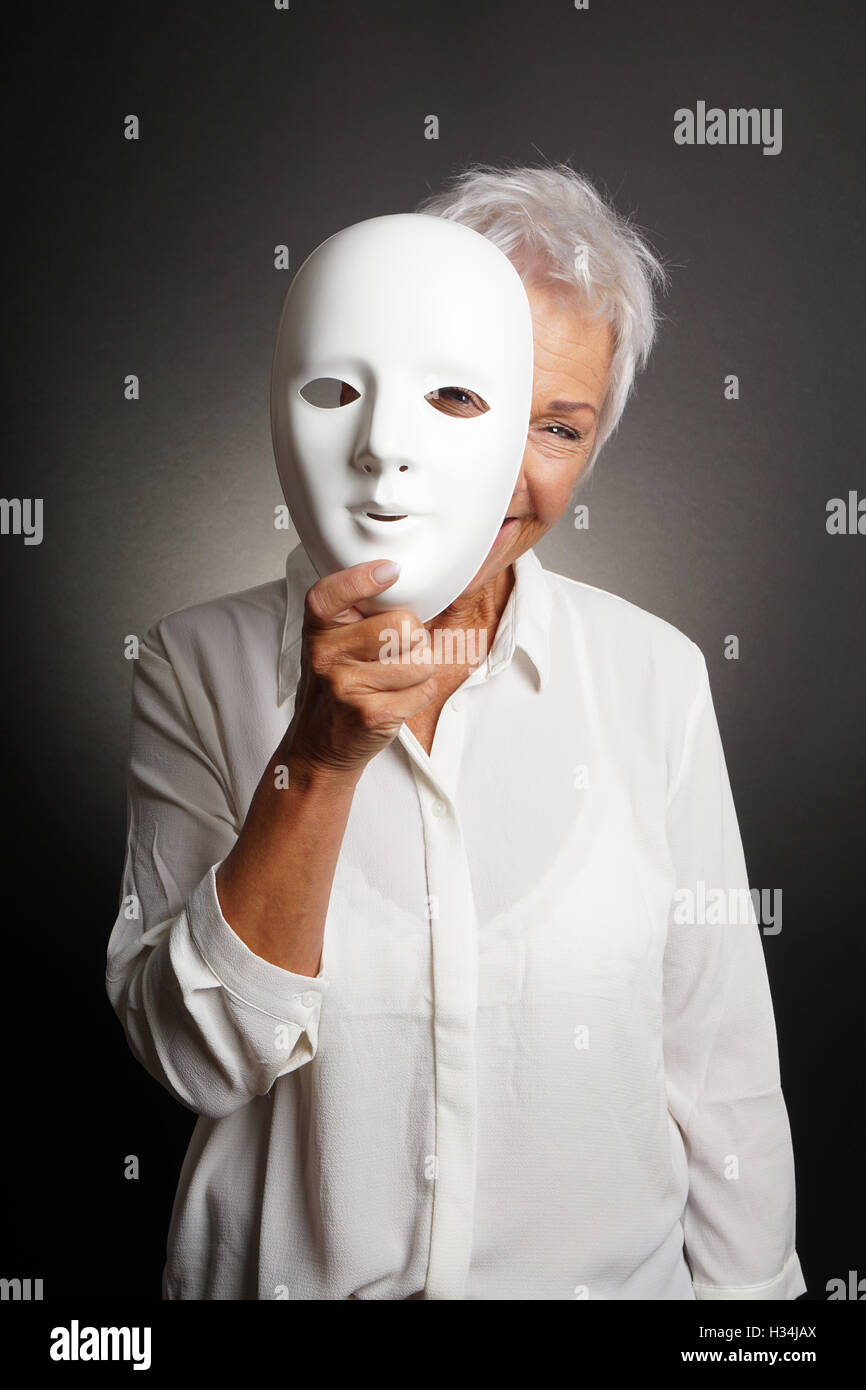 Mature Woman peeking de derrière le masque Banque D'Images