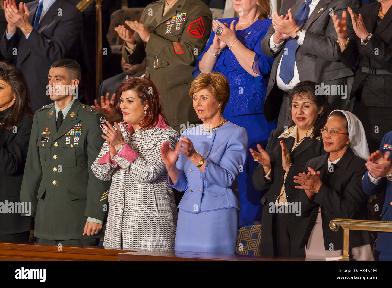 WASHINGTON, DC, USA - La Première dame Laura Bush, centre, à l'écoute de son mari le président George W. Bush prononce son discours sur l'état de l'Union devant le Congrès le 2 février 2005. De chaque côté de Mme Bush sont deux femmes de l'Afghanistan et l'Iraq qui ont voté dans leur pays à des élections démocratiques. Banque D'Images