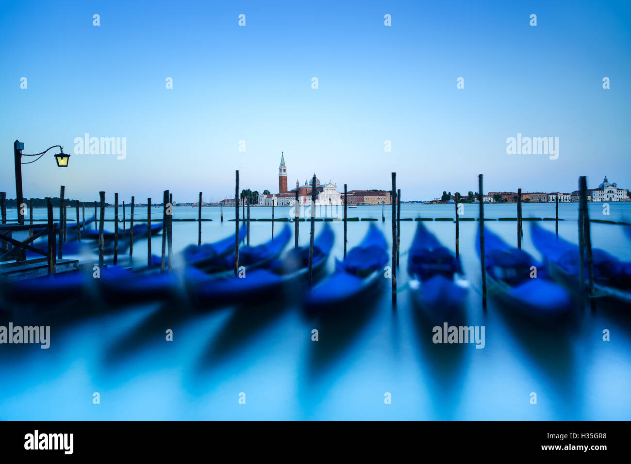Venise, gondoles ou gondole sur un coucher de soleil bleu crépuscule et église San Giorgio Maggiore vue sur arrière-plan. L'Italie, l'Europe. Banque D'Images