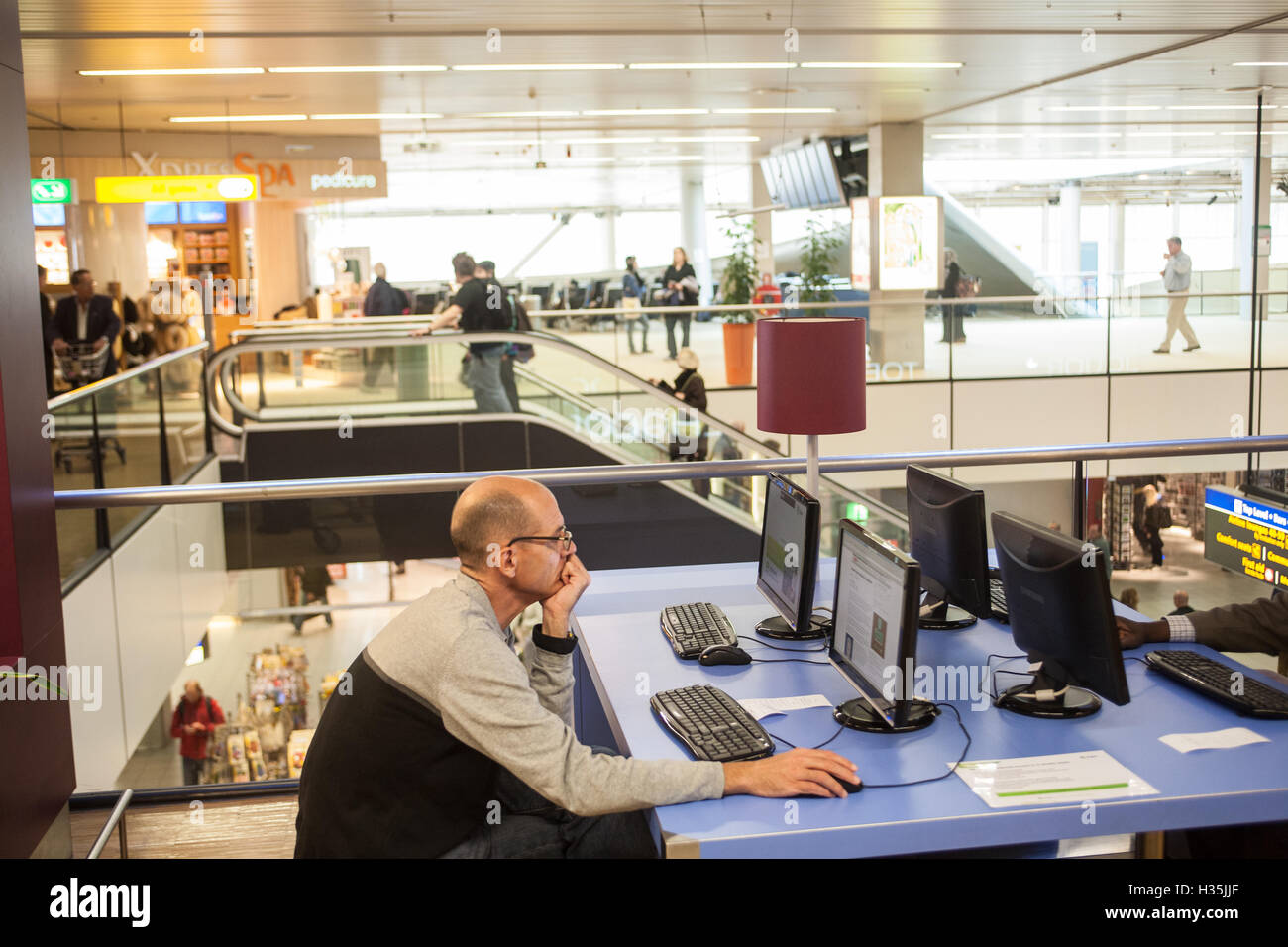 Devant un ordinateur à la borne à l'aéroport Schipol d'Amsterdam, Hollande, Pays-Bas,,l'Europe. Banque D'Images