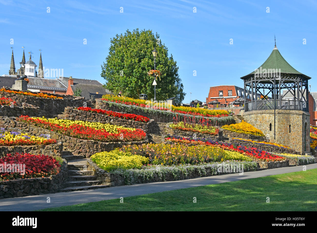 Fleurs d'afficher sur un remblai en terrasses dans les jardins du parc à côté de kiosque dans parc du château, Tamworth, Staffordshire England UK Banque D'Images