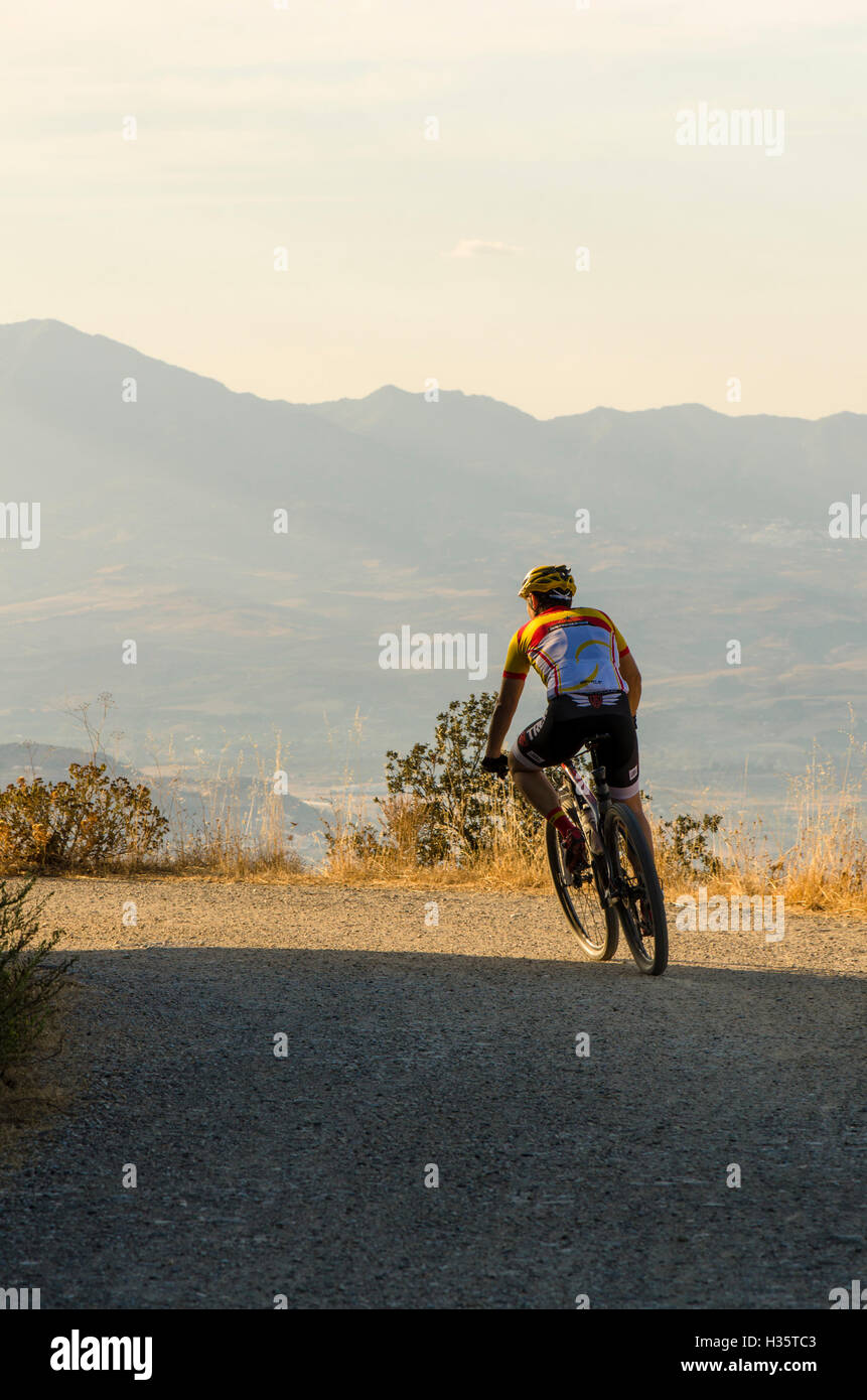 L'homme en montagne, VTT, randonnée à vélo, l'exercice au coucher du soleil, Mijas, Costa del Sol, Espagne. Banque D'Images