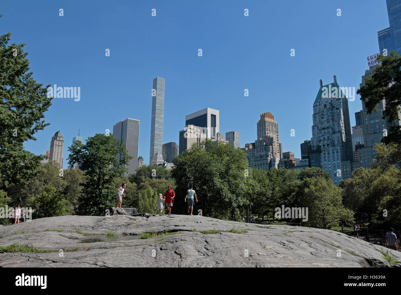 Les enfants jouant sur les juge-arbitre Rock, Central Park. Vue vers le sud en direction de Midtown Manhattan, New York City, New York, United States. Banque D'Images