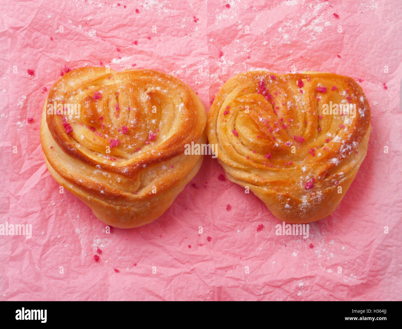 Deux petits pains en forme de cœur sur le fond rose Banque D'Images