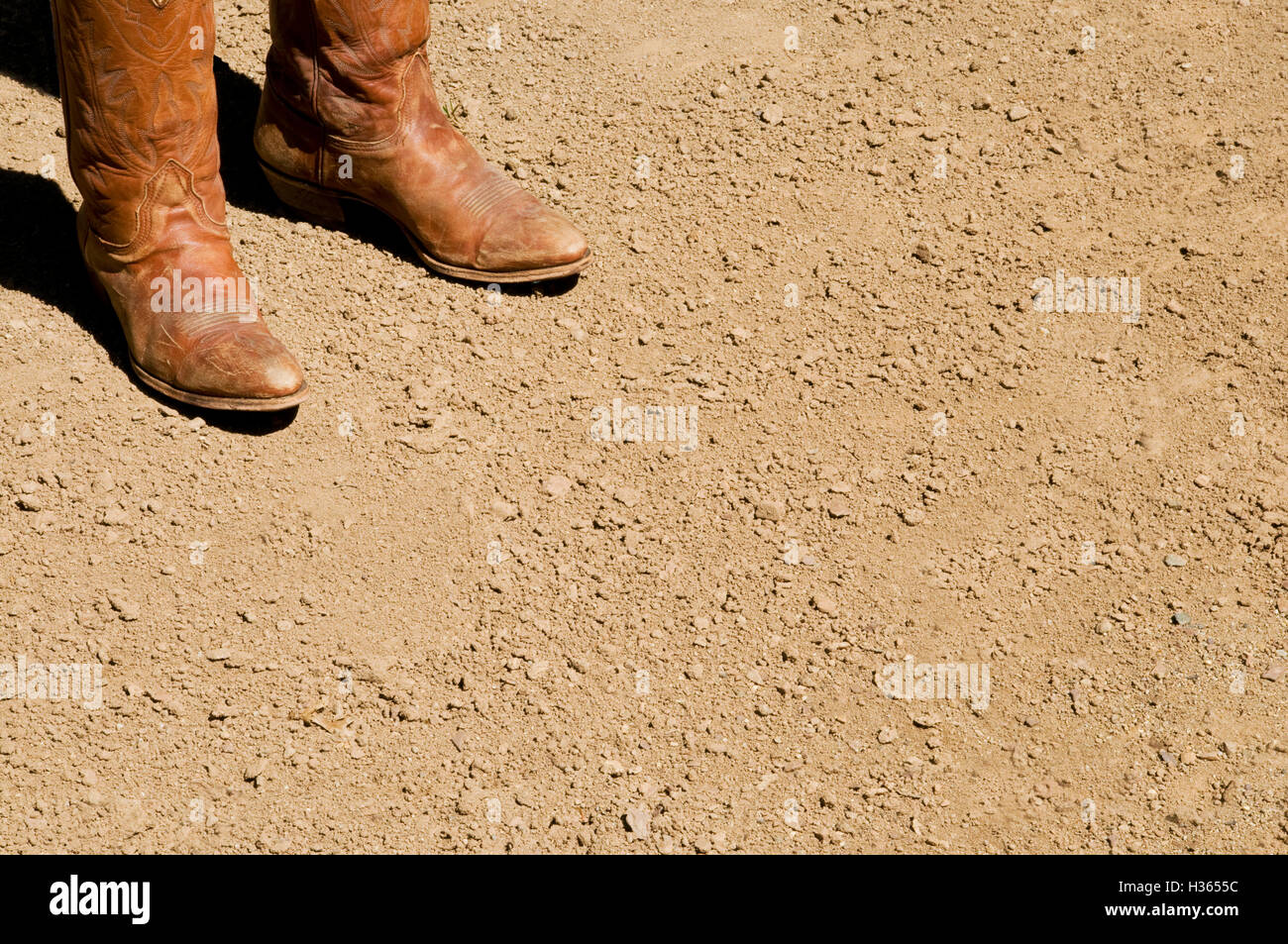 Deux western sales bottes de cow-boy debout sur sol de terre sèche Banque D'Images
