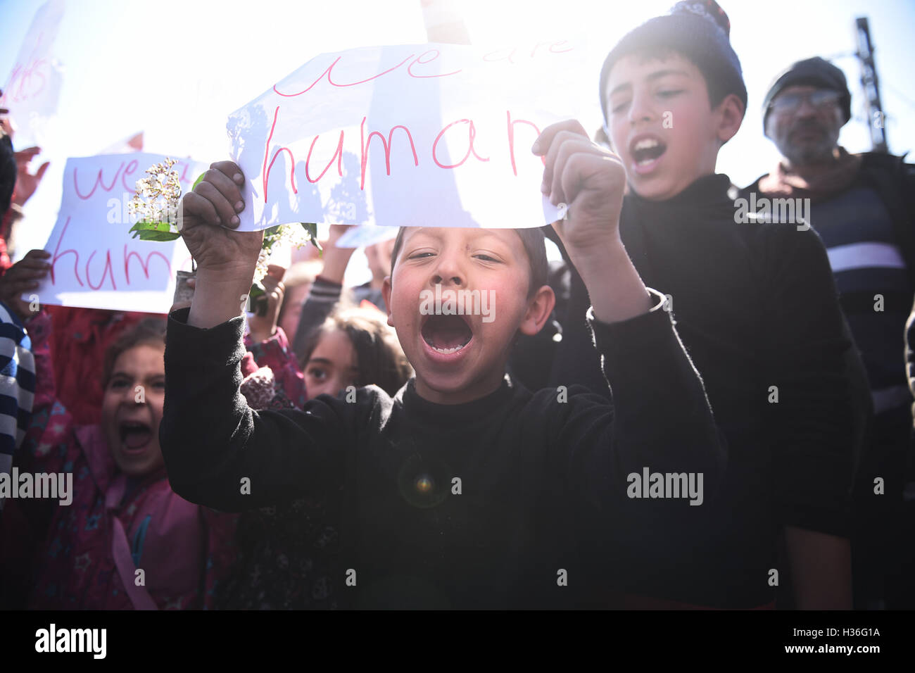 Les enfants crier des slogans, comme les réfugiés et les migrants montrer exigeant pour les frontières de l'Union européenne d'ouvrir, dans un camp de réfugiés, au nord du village grec de Idomeni. Des milliers de réfugiés et migrants ont été bloqués pendant des mois à la frontière macédonienne, dans le camp de réfugiés près du village de Idomeni, jusqu'à ce que le gouvernement grec a décidé d'évacuer la zone. Banque D'Images