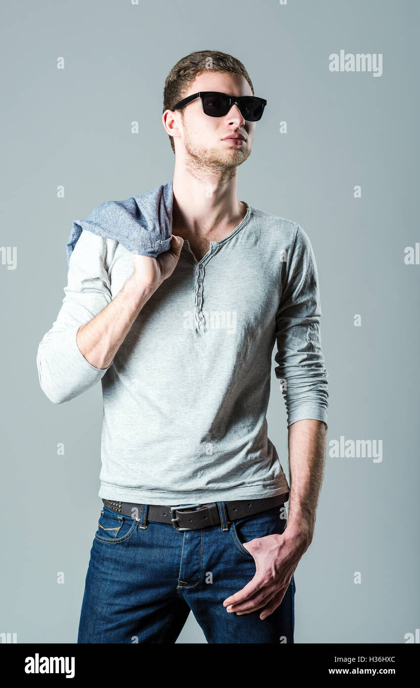 Fashion shot : beau jeune homme portant des jeans, shirt et lunettes Banque D'Images