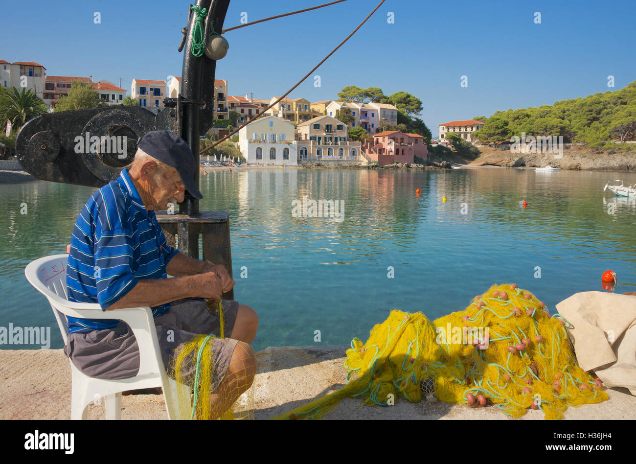 Vieux Pêcheur réparant les filets de pêche Îles Ioniennes Grèce Céphalonie Assos Banque D'Images