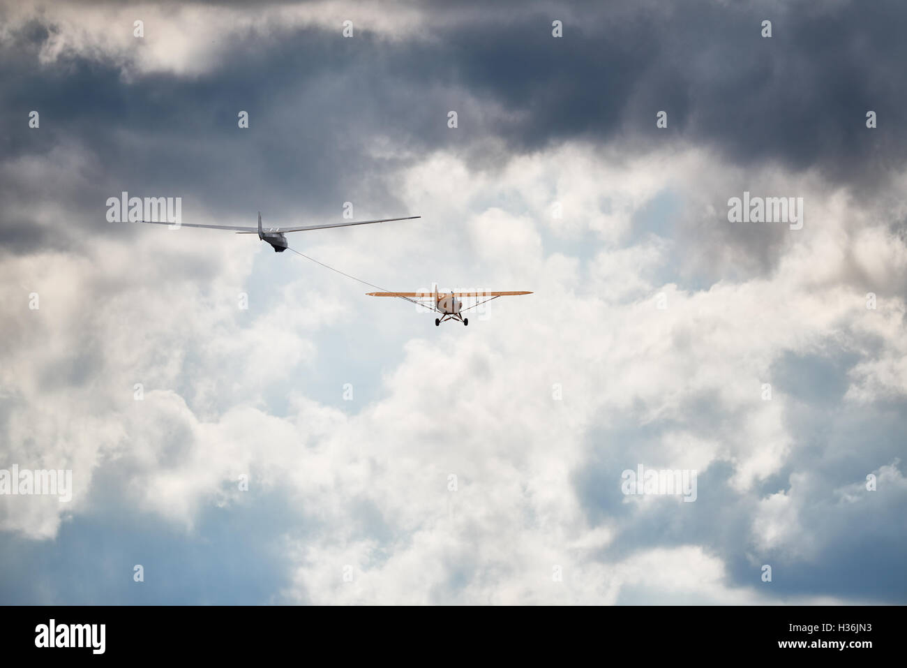 Un sailglider Towplane avec makeing leur chemin dans le ciel nuageux. Banque D'Images