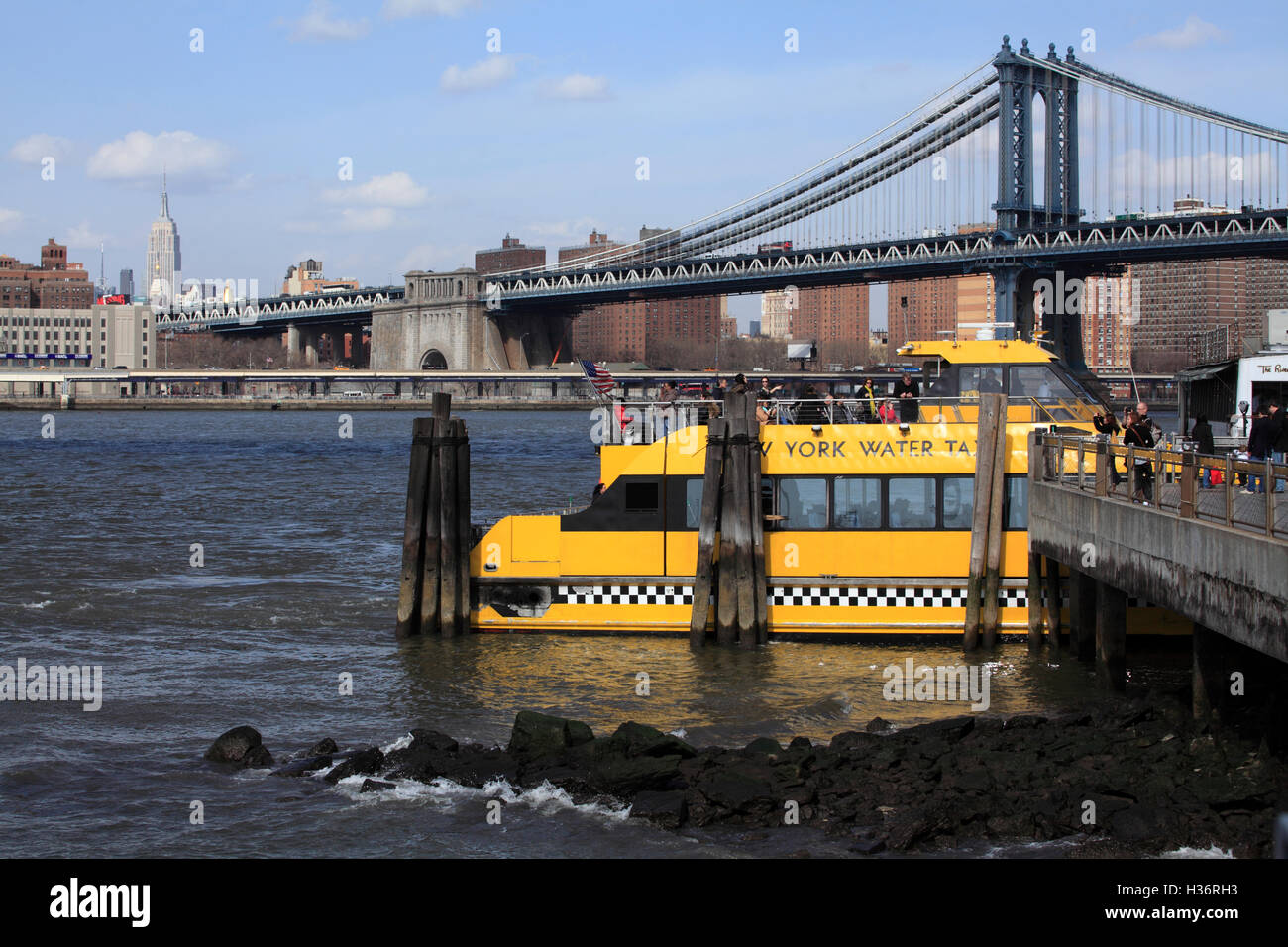 Un New York Water Taxi à Fulton Ferry Landing avec Manhattan Bridge & Empire State Building en arrière-plan.New York City.USA Banque D'Images