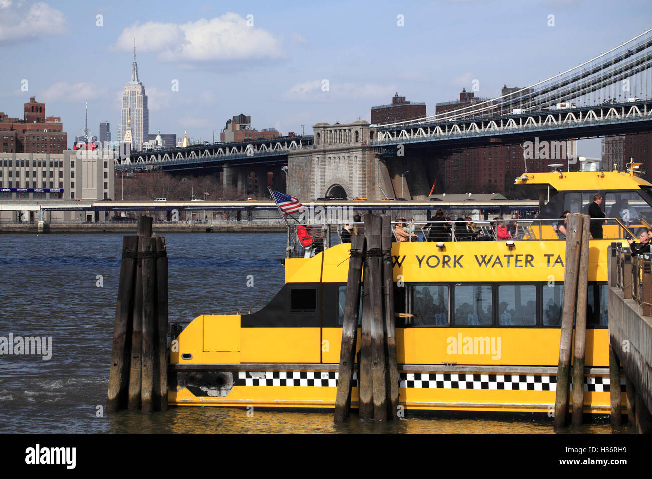 Un New York Water Taxi à Fulton Ferry Landing avec Manhattan Bridge & Empire State Building en arrière-plan.New York City.USA Banque D'Images